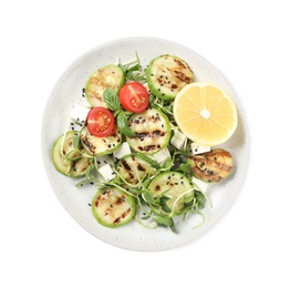 Photo of Delicious grilled zucchini slices served with feta cheese, tomatoes and lemon on white background, top view