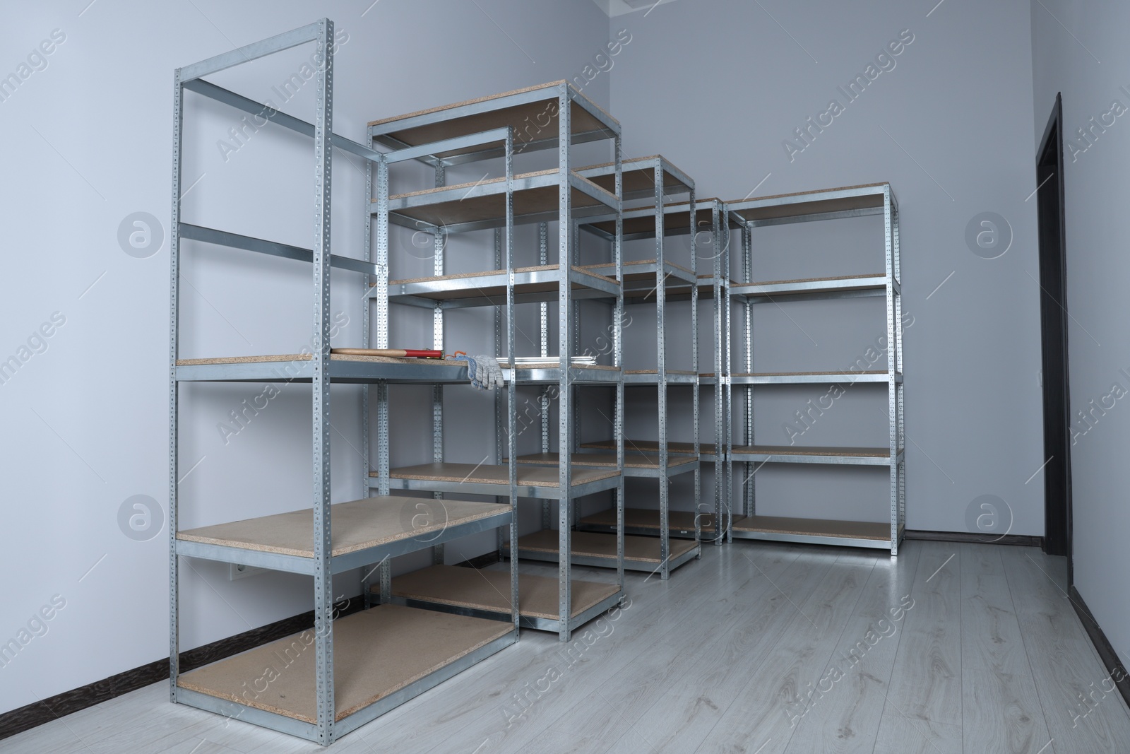 Photo of Office room with white walls and metal storage shelves