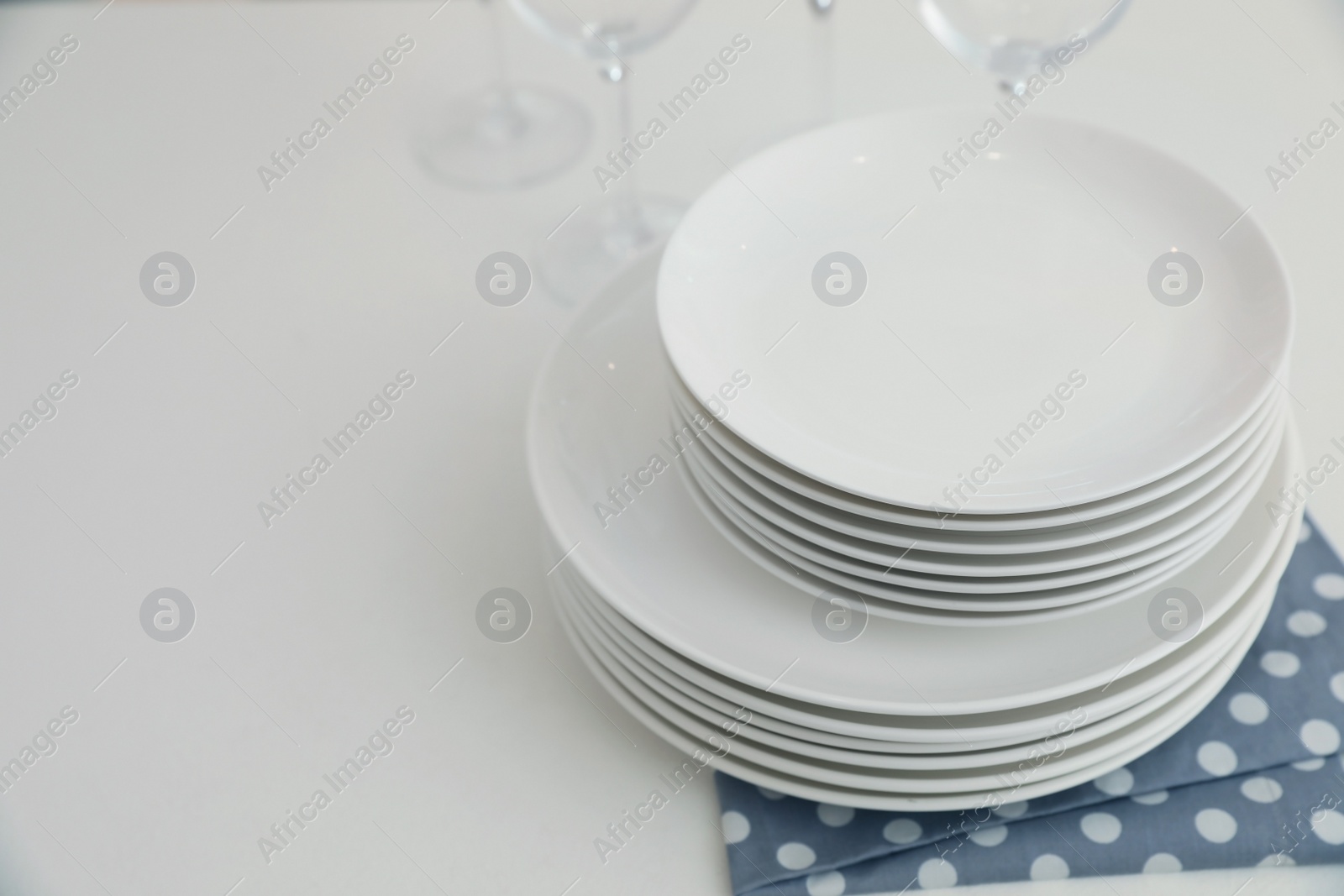 Photo of Stack of clean dishes on table in kitchen. Space for text