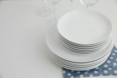 Stack of clean dishes on table in kitchen. Space for text