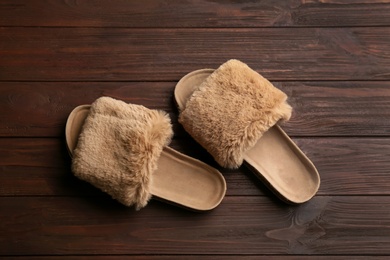 Pair of soft slippers on wooden background, flat lay