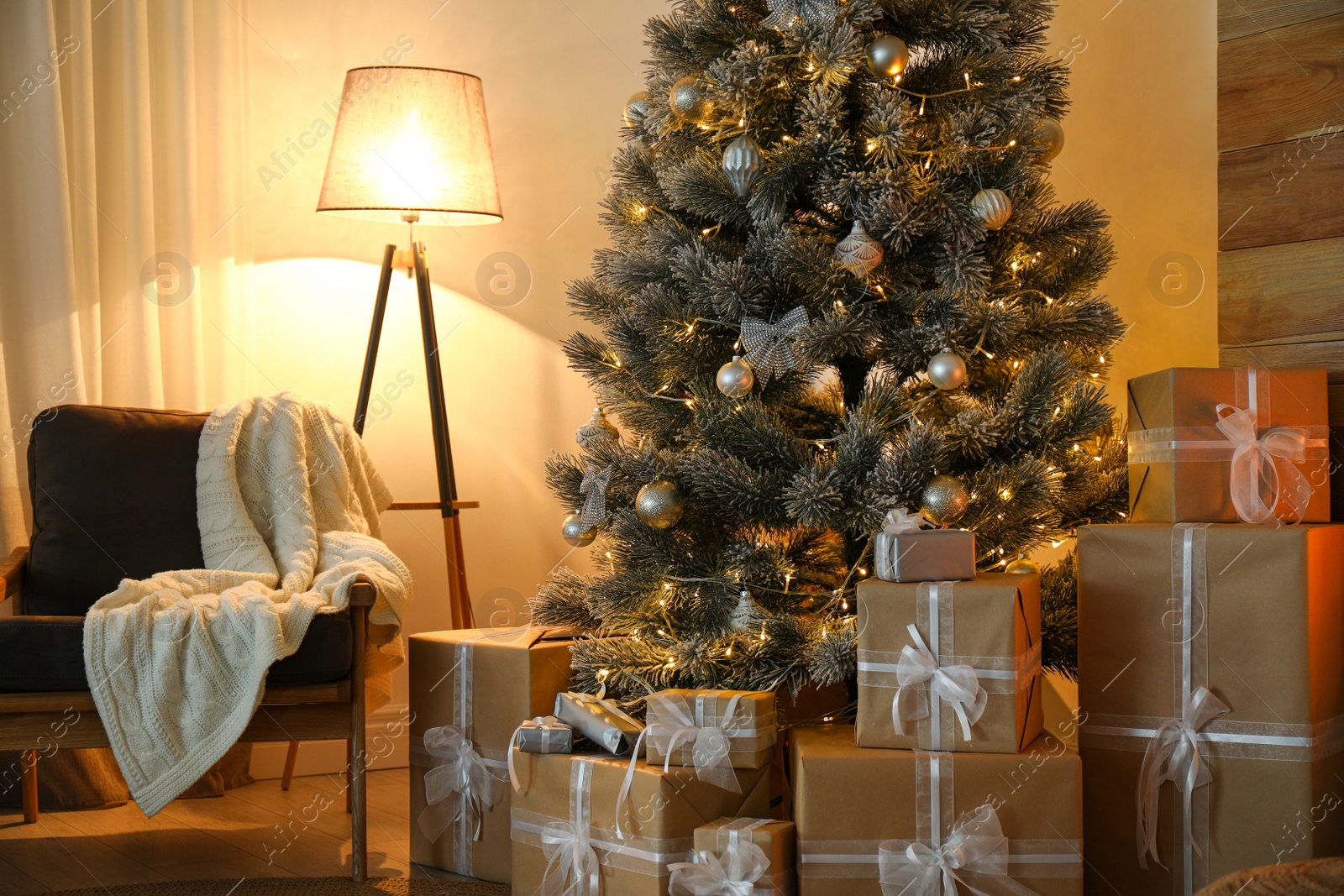 Photo of Stylish room interior with beautiful Christmas tree and gift boxes