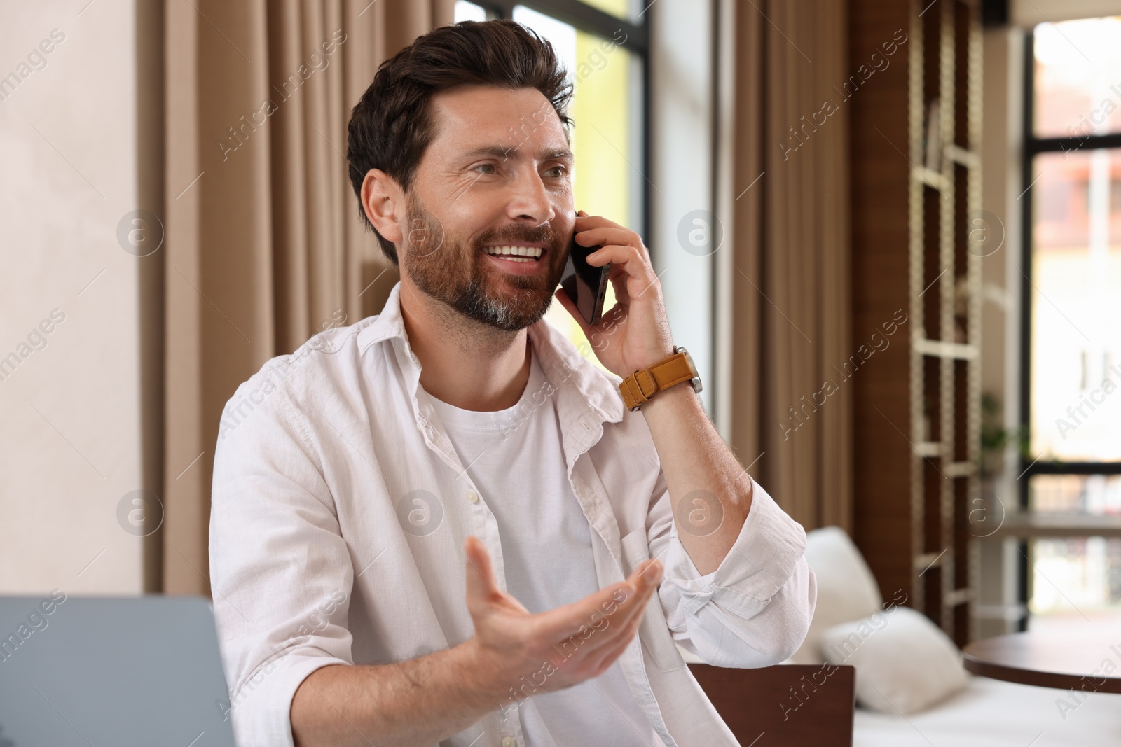 Photo of Handsome man talking on phone in cafe