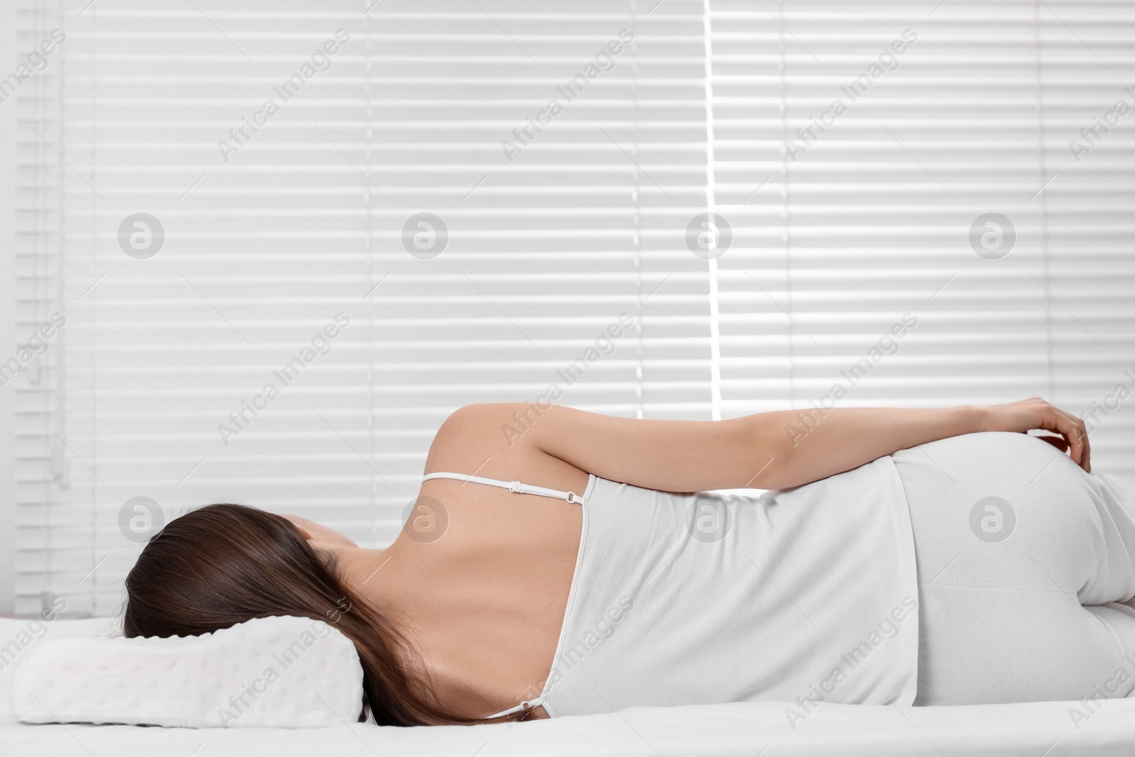 Photo of Woman sleeping on orthopedic pillow at home, space for text