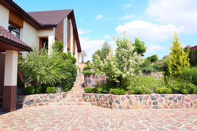 Landscape with modern house and beautiful garden on sunny day