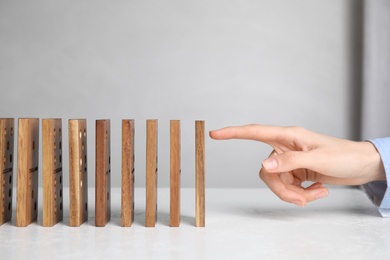 Woman with wooden dominoes at white table, closeup