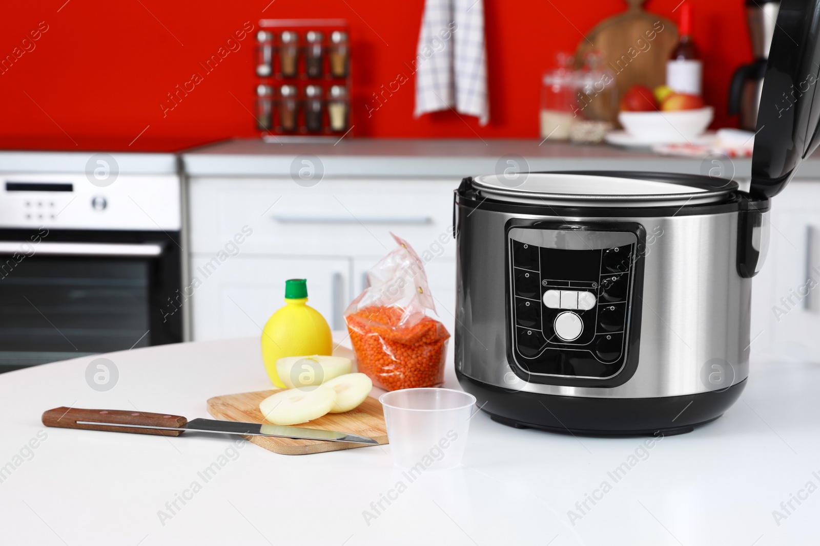 Photo of New modern multi cooker and products on table in kitchen. Space for text