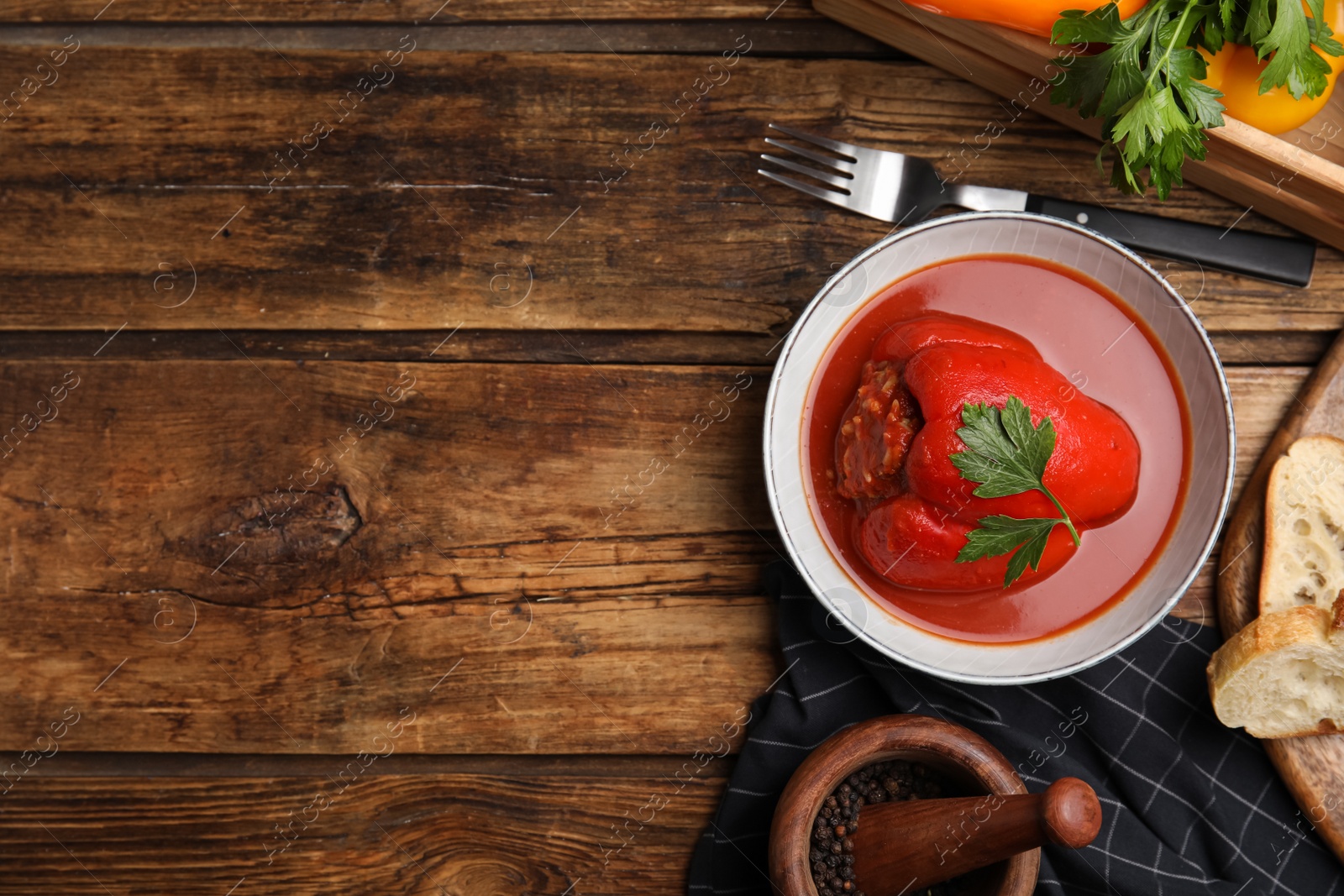 Photo of Delicious stuffed pepper served on wooden table, flat lay. Space for text