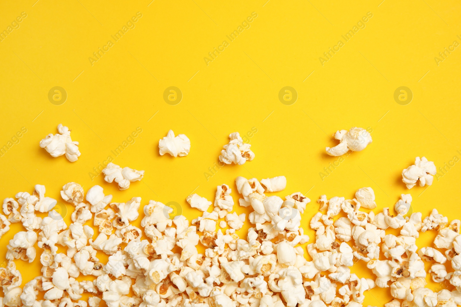 Photo of Tasty fresh popcorn on color background, top view