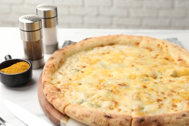 Photo of Delicious cheese pizza and spices on white table, closeup