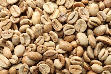 Many green coffee beans as background, top view