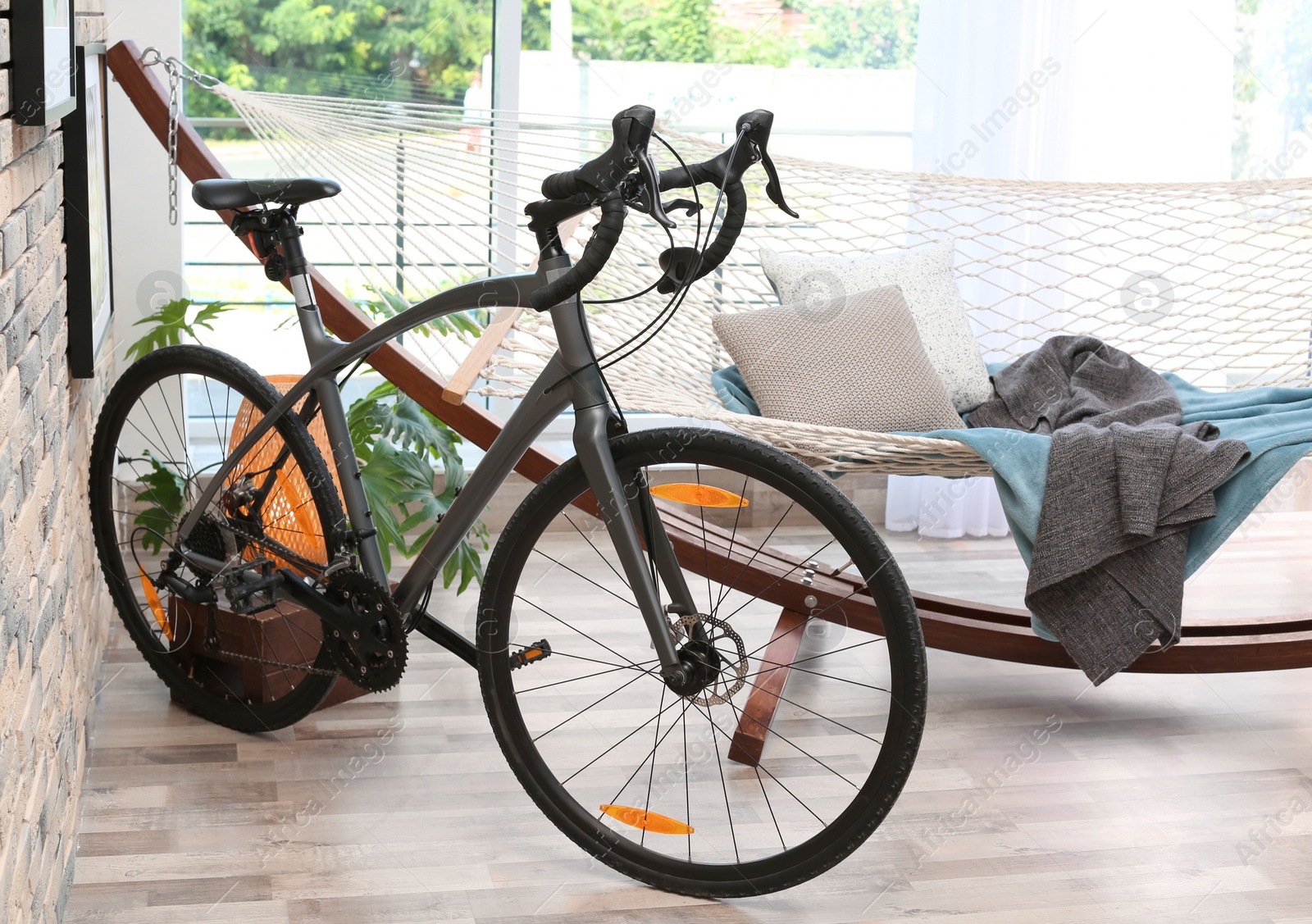 Photo of Modern bicycle and hammock in stylish room interior