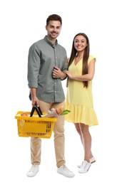 Photo of Young couple with shopping basket full of products isolated on white