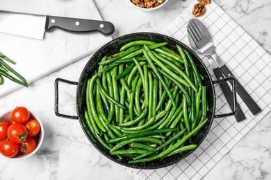 Dish with tasty green beans served for dinner on table, top view