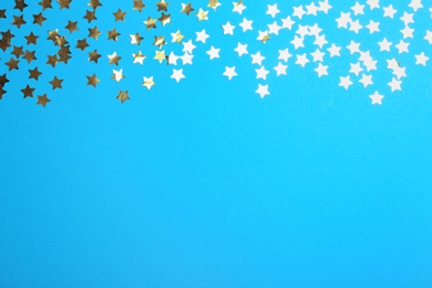 Confetti stars with space for text on blue background, top view. Christmas celebration