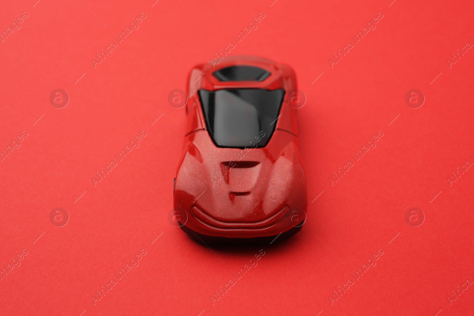 Photo of One bright car on red background. Children`s toy