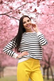 Photo of Pretty young woman in park with blooming trees. Spring look