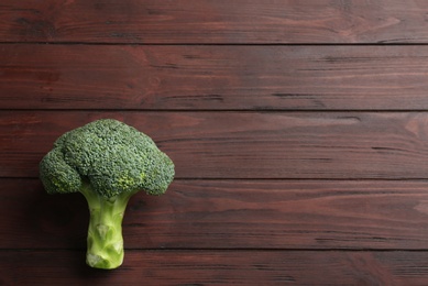 Photo of Fresh green broccoli on wooden table, top view. Space for text