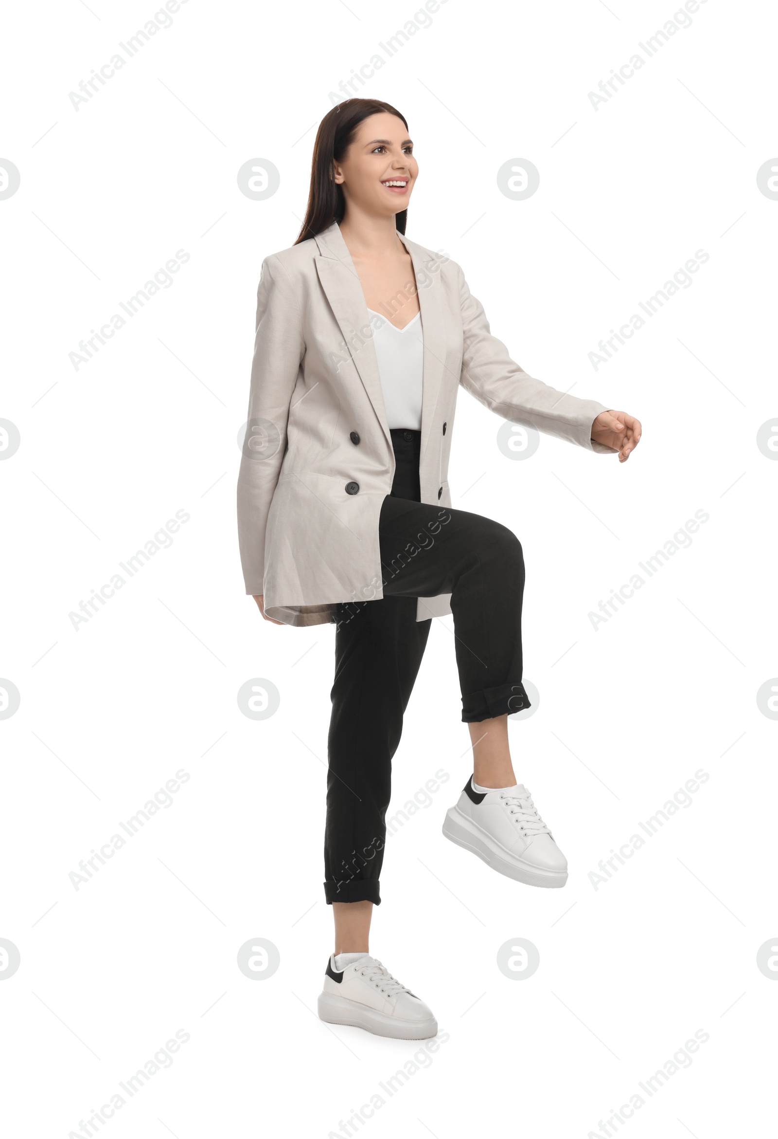 Photo of Beautiful businesswoman in suit walking on white background