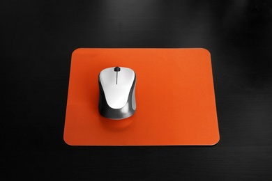 Blank pad and wireless computer mouse on black background
