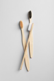 Bamboo toothbrushes on white background, flat lay
