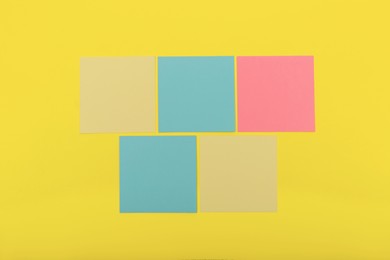 Colorful sticky notes on yellow background, flat lay