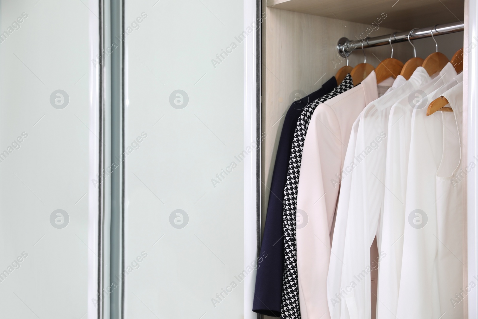 Photo of Wardrobe closet with different stylish clothes in room, closeup