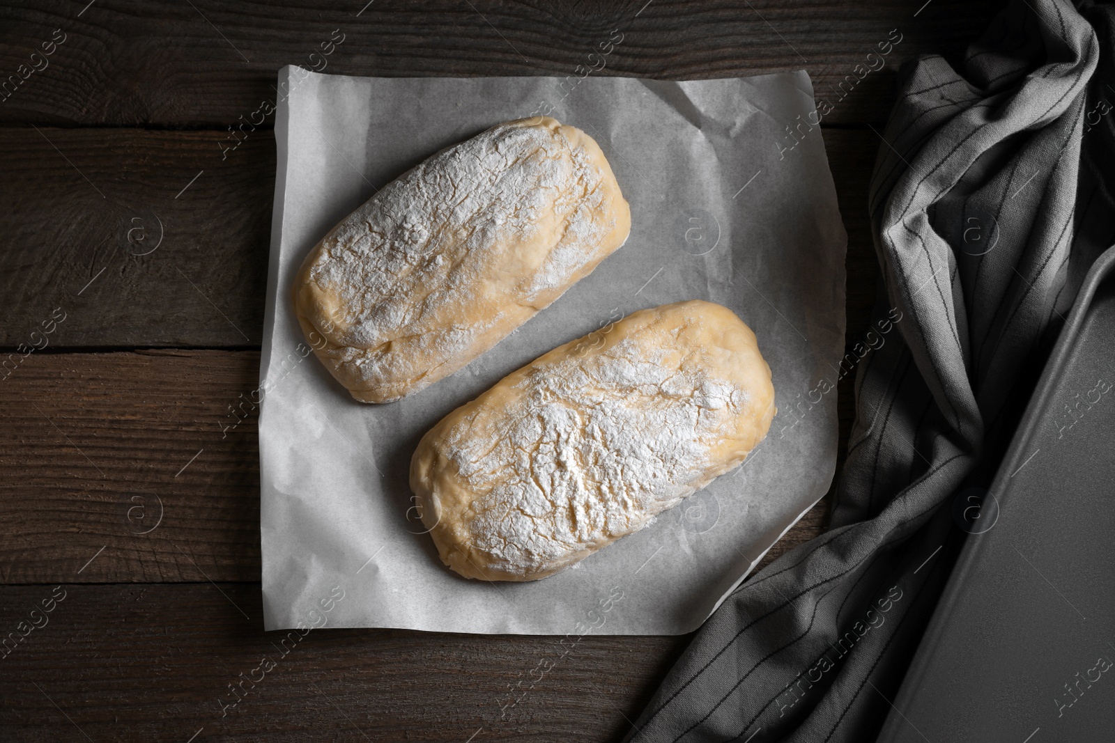 Photo of Raw dough for ciabatta and flour on wooden table, flat lay