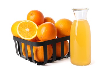 Fresh oranges in metal basket and bottle of juice isolated on white