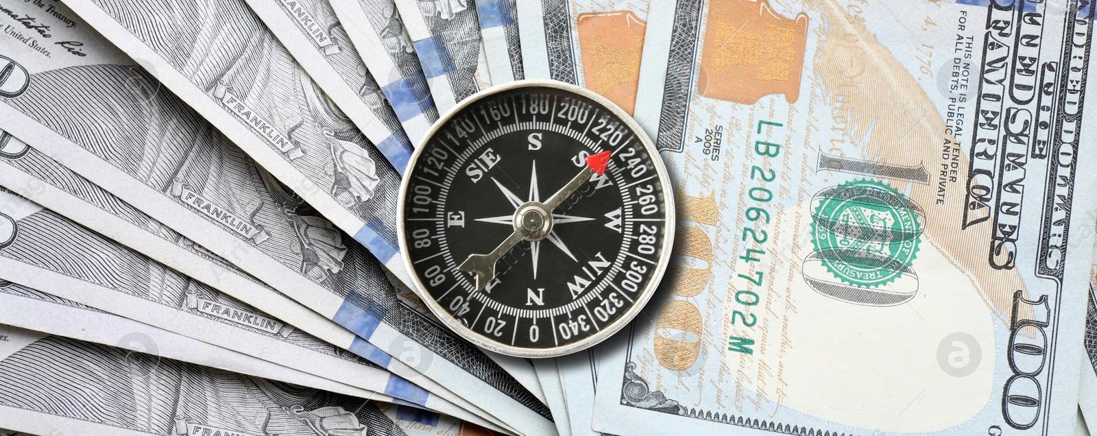 Image of Exchange rate. Money (dollar banknotes) and compass as background, top view. Banner design