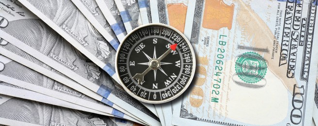 Exchange rate. Money (dollar banknotes) and compass as background, top view. Banner design