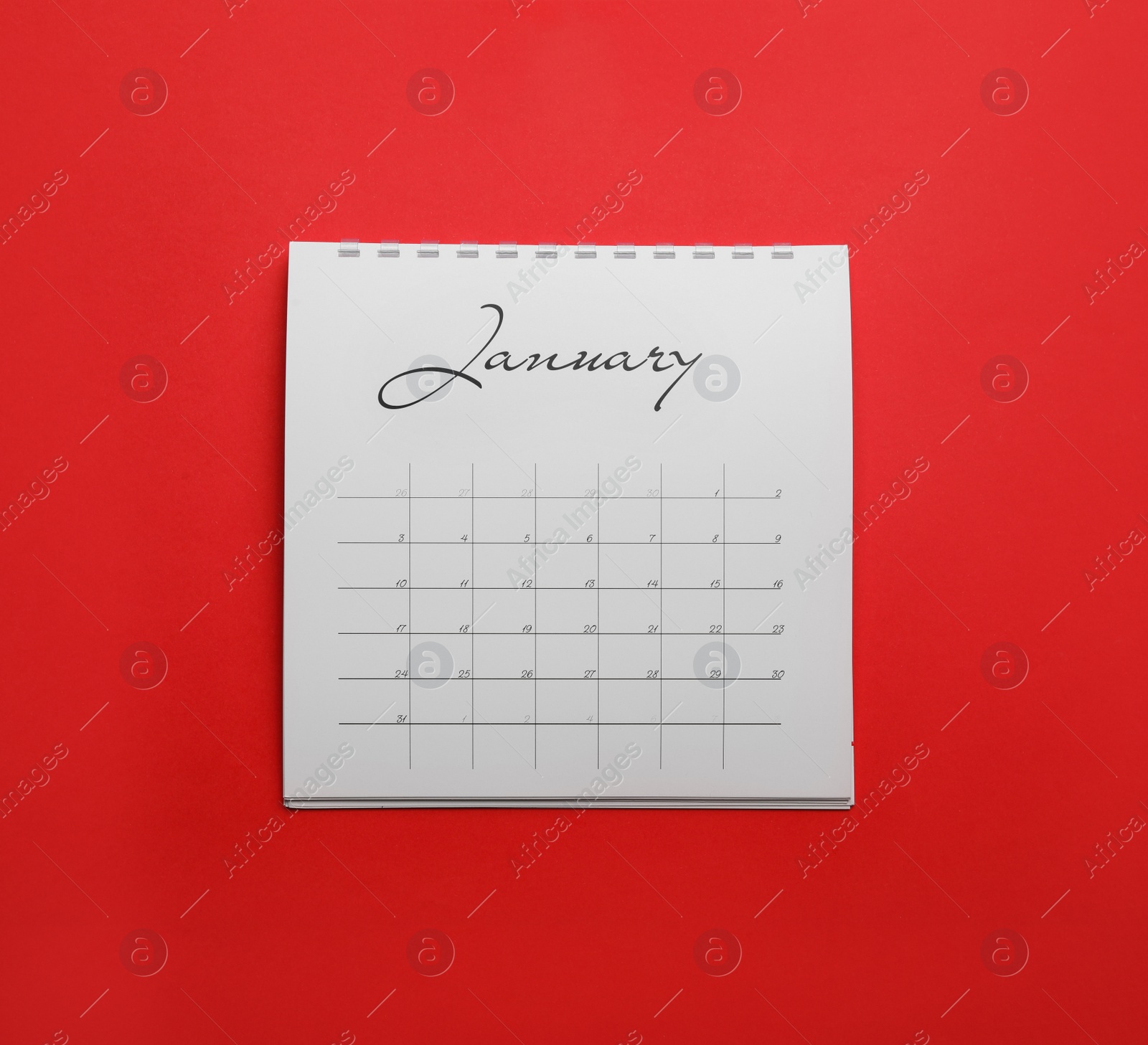 Photo of January calendar on red background, top view