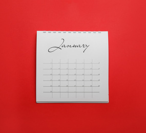 Photo of January calendar on red background, top view