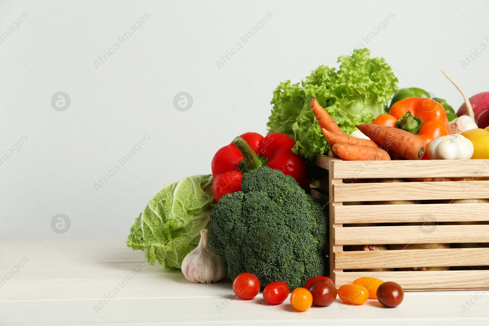 Photo of Assortment of fresh vegetables on white wooden table. Space for text