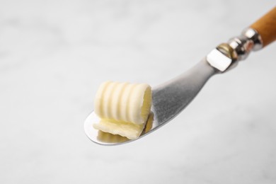 Photo of Tasty butter curl and knife on white background, closeup