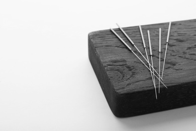 Photo of Board with needles for acupuncture on white background