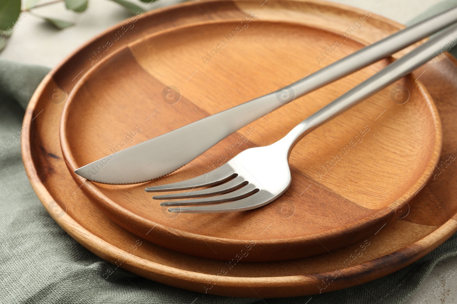 Photo of Stylish setting with cutlery, napkin and plates on table, closeup