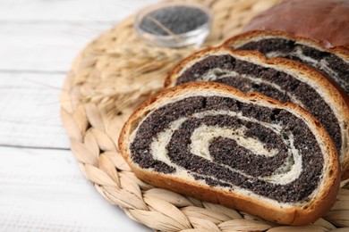 Photo of Cut poppy seed roll on white wooden table, closeup with space for text. Tasty cake