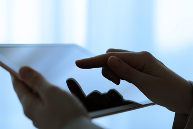 Photo of Closeup view of woman using modern tablet on blurred background