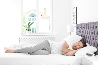 Young man sleeping in bed at home