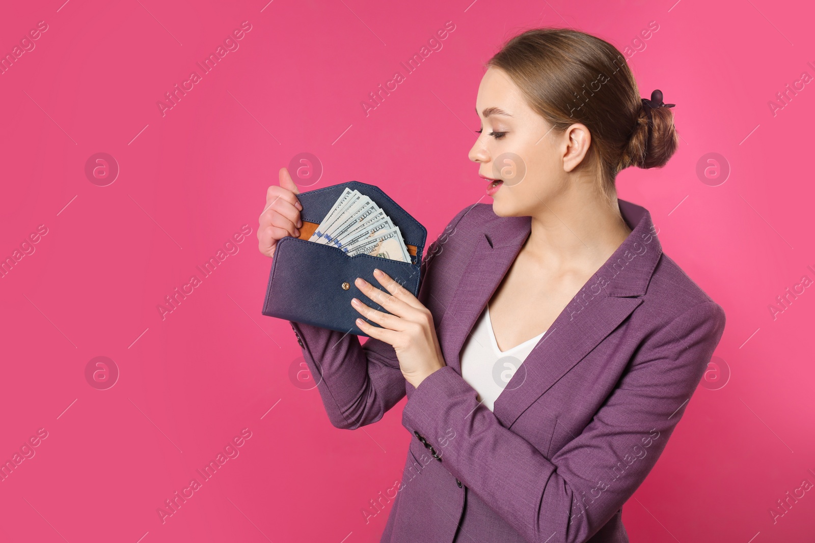 Photo of Happy young businesswoman with wallet full of money on color background. Space for text