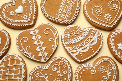 Tasty heart shaped gingerbread cookies on yellow background, flat lay