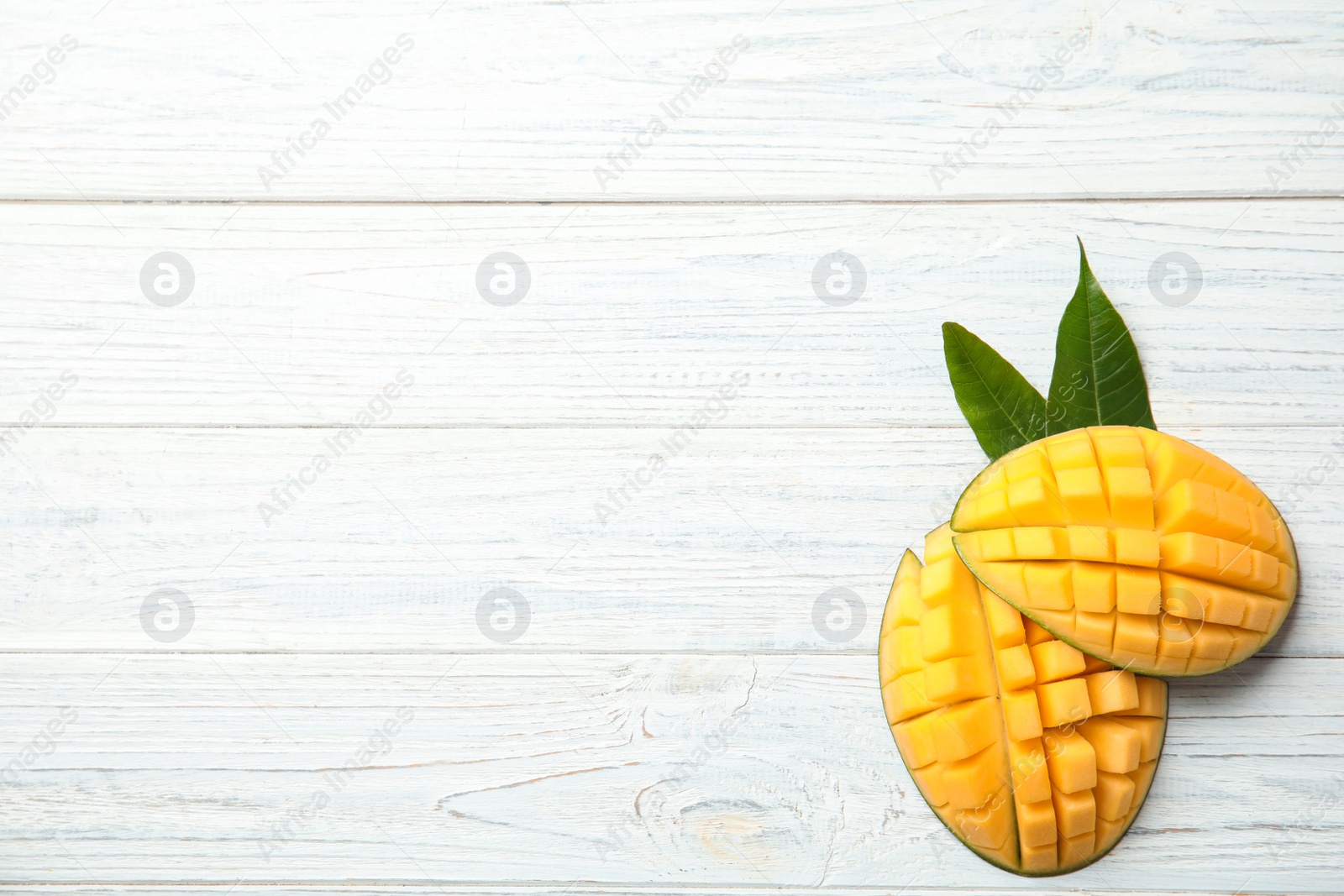 Photo of Flat lay composition with cut mango and space for text on white wooden background