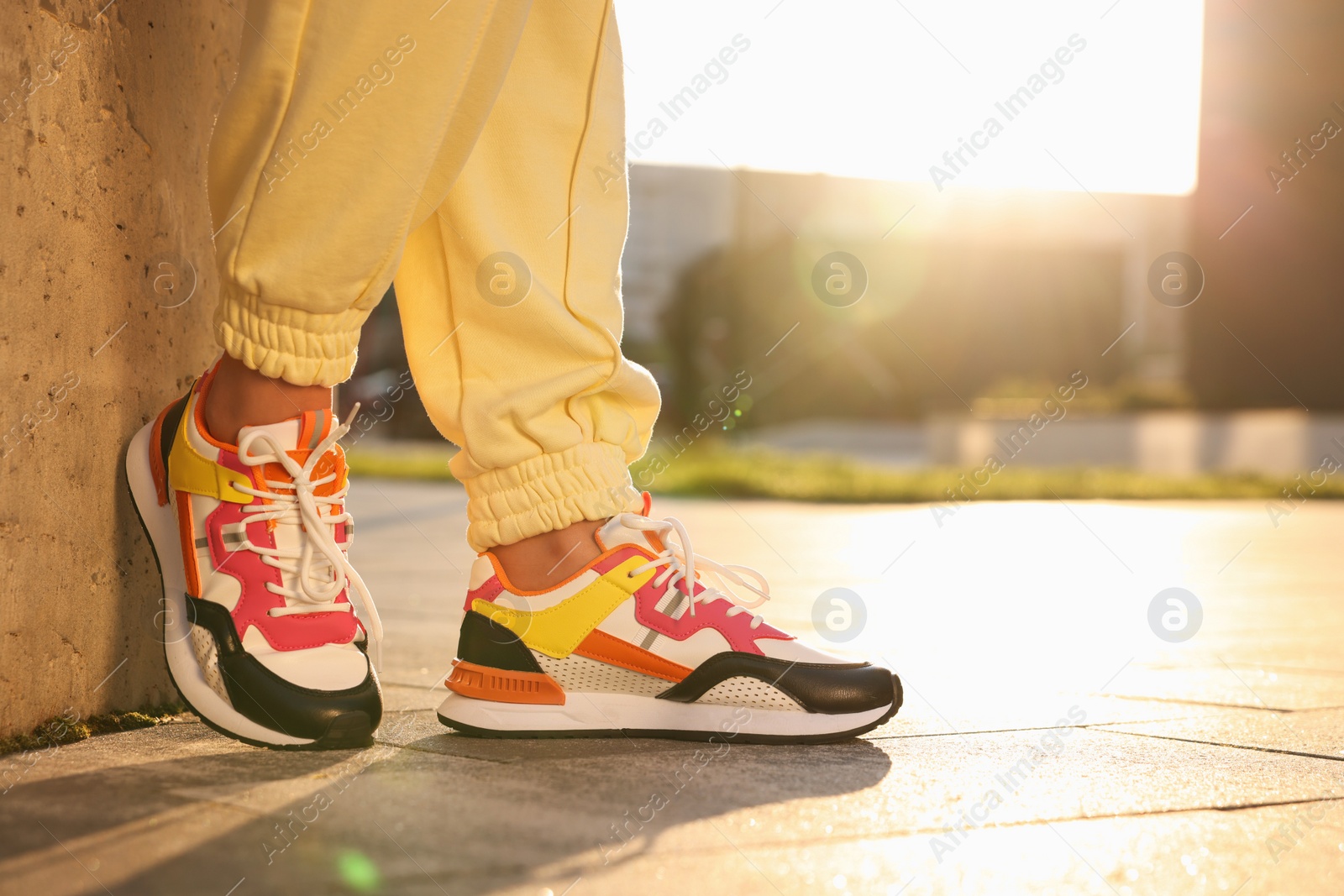 Photo of Woman wearing stylish sneakers outdoors, closeup. Space for text