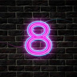 Image of Glowing neon number 8 sign on brick wall