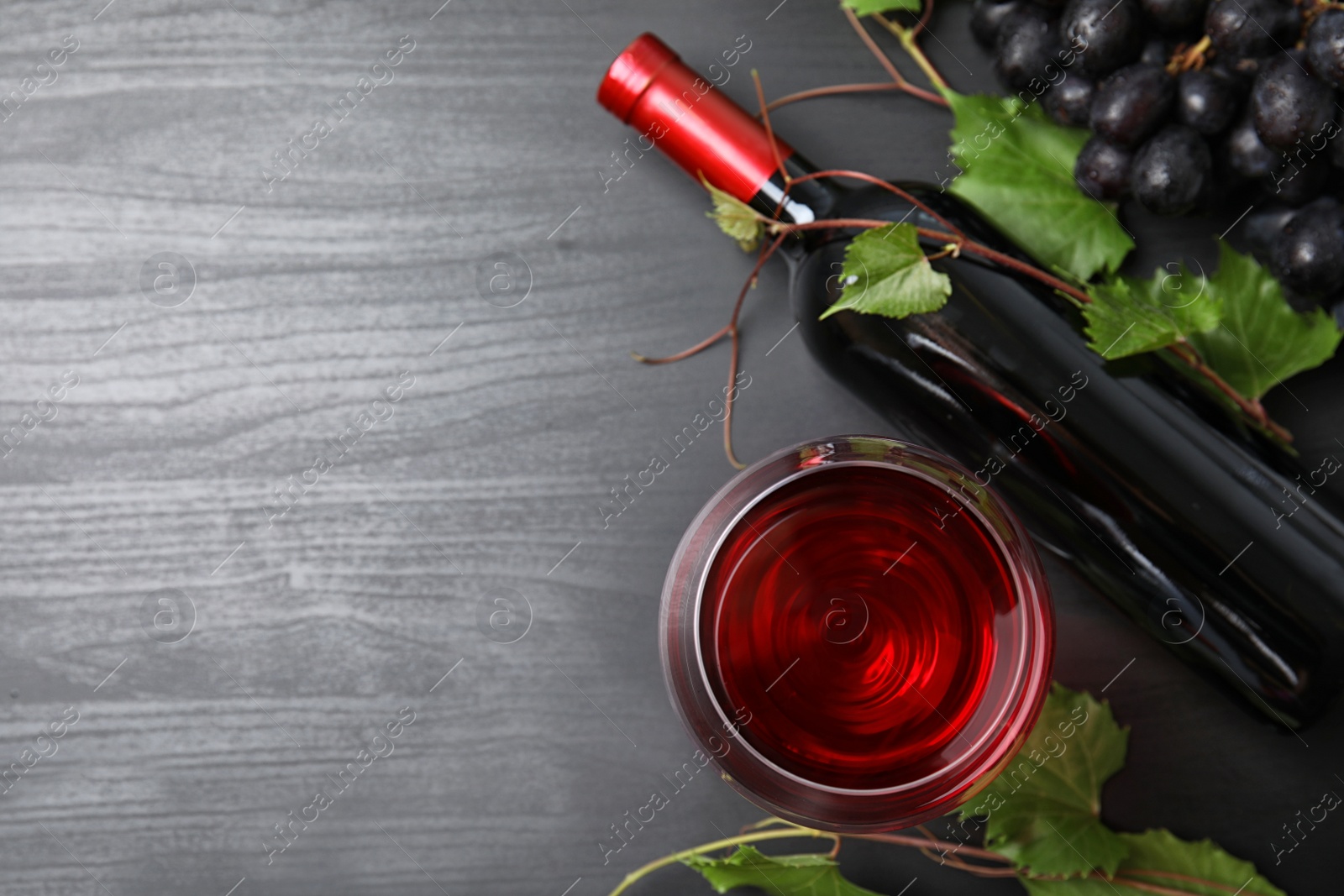 Photo of Flat lay composition with fresh ripe juicy grapes and space for text on wooden background