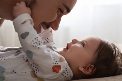 Father playing with his daughter indoors, closeup