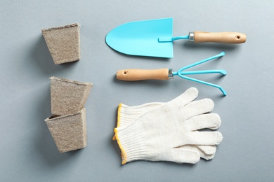 Photo of Flat lay composition with professional gardening tools on grey background