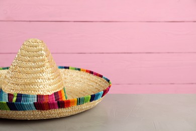 Photo of Mexican sombrero hat on grey table, closeup. Space for text