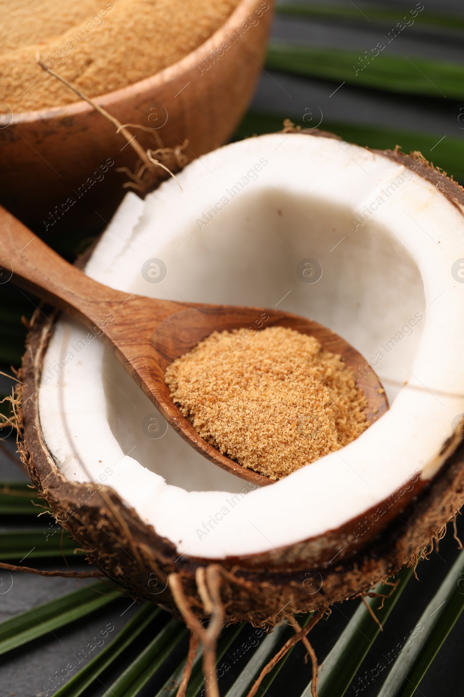 Photo of Spoon with coconut sugar and fruit on table, closeup